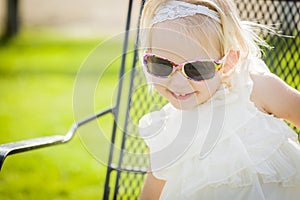 Blonde Playful Baby Girl Wearing Sunglasses Outside at Park