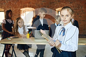 Blonde pretty girl holding folders and documants looking at the camera