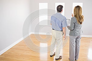 Blonde realtor showing a room to a potential buyer