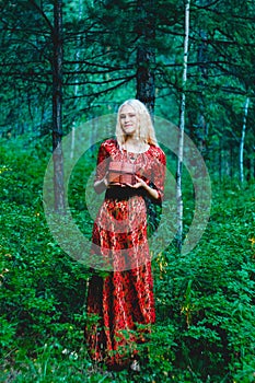 A blonde in a red dress in the woods