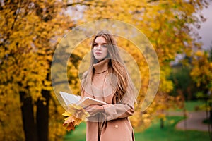 Blonde redhead young female walking in the autumn park