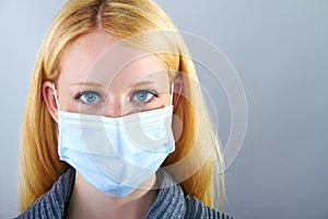 Blonde serious woman with surgical mask