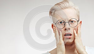 Blonde shocked man with wide opened mouth and bugged eyes shouting with horror.