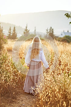 Blonde slavic girl on the field in the evening