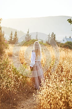 Blonde slavic girl on the field in the evening