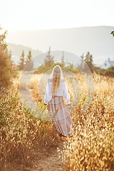 Blonde slavic girl on the field in the evening