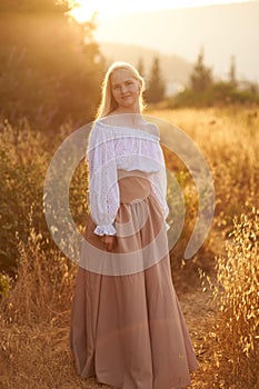 Blonde slavic girl on the field in the evening