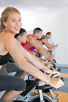 Blonde smiling at camera during spin class