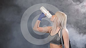 Blonde sportswoman going to gym with bag and shaker for gym. Sports lifestyle