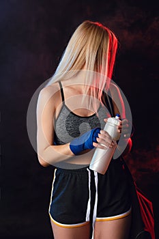 Blonde sportswoman going to gym with bag and shaker for gym. Sports lifestyle