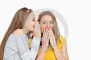 Blonde student whispering to her voiceless friend photo