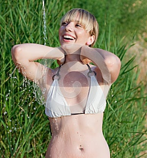 Blonde taking shower outdoors