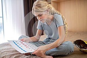 A blonde teen ,marking days of her periods in a calendar