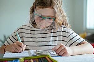 Blonde teen schoolgirl doing her written homework