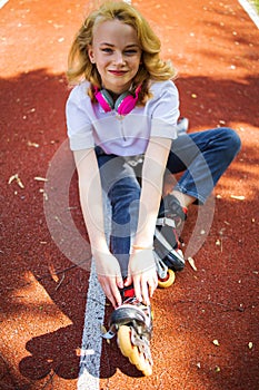 Teenage Girl Wearing Roller Skaters While Standing On The Road In Summe Park. photo