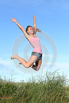 Blonde teenager girl jumping happy in the mountain