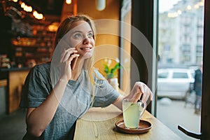 Blondýnka používá telefon.. žena je v kavárna buněčný 