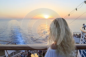 Blonde watching sunset from cruise ship