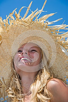 Blonde wearing straw hat on sunny beach