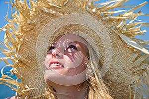 Blonde wearing straw hat on sunny beach