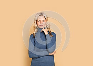 Blonde woman adult attractive beautiful calm  portrait  face, cauasian and scandinavian girl in blue sweater on yellow background photo