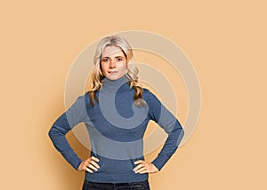 Blonde woman adult attractive beautiful calm  portrait  face, cauasian and scandinavian girl in blue sweater on yellow background photo