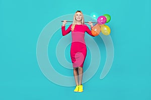 Blonde woman with balloons on blue