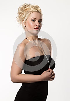 Blonde woman with beautiful curls posing on a light background. Girl with curly hairstyle and lips