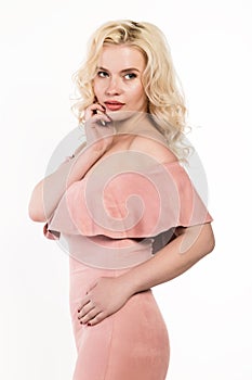 Blonde woman with beautiful curls posing on a light background. Girl with curly hairstyle and lips