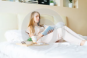 Blonde woman in bed with book