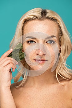 blonde woman with blemishes massaging face photo