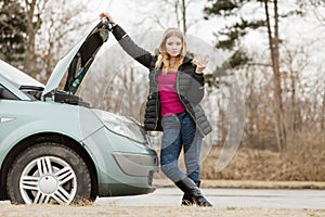 Blonde woman and broken down car on road