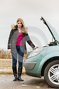 Blonde woman and broken down car on road