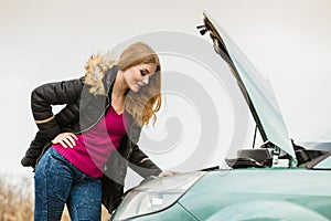 Blonde woman and broken down car on road