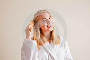Blonde woman brushing her blonde healthy hair