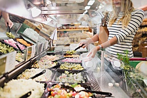 Blonde woman buying pasta prepared meal