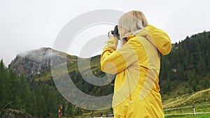 Blonde woman captures the beauty of the Alpine meadows