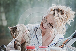 Blonde woman with a cat at breakfast time.