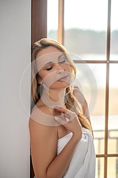 Blonde woman with closed eyes and bare shoulders