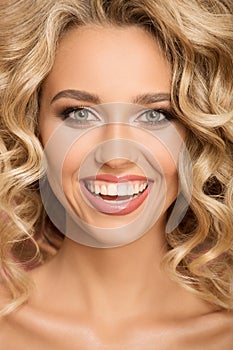 Blonde woman with curly beautiful hair smiling.