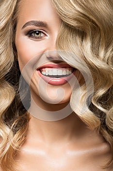 Blonde woman with curly beautiful hair smiling.