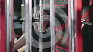 Blonde woman does Lat pulldown at gym