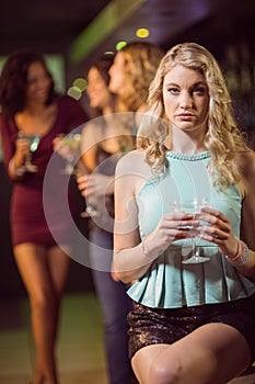 Blonde woman drinking cocktail