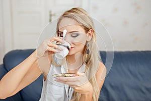 Blonde woman drinking coffee in living room