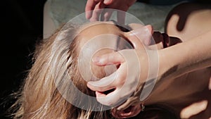 Blonde woman getting head massage in spa. eastern medicine concepte, tai massage