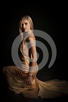 blonde woman in golden revealing evening dress