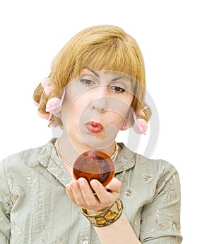 Blonde woman with hair curlers looking into mirror