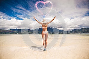 Blonde woman with hat walking towards love