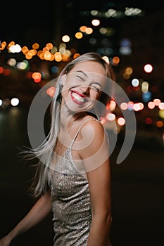 blonde woman having fun at night city street.