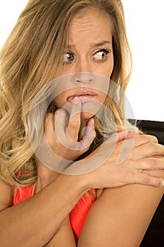 Blonde woman head shot close finger on mouth scared